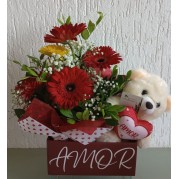 Cesta com flores e urso de pelúcia.